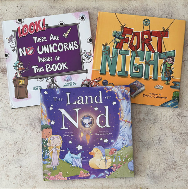 Three children's picture books by renowned author Jimmy Vee are arranged on a beige patterned tray. The books are titled 'Look! These Are No Unicorns Inside of This Book', 'The Land of Nod', and 'Fort Night'.